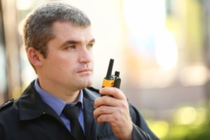 AF Patrol security guard using a walkie-talkie to coordinate safety at an event in Orange County.